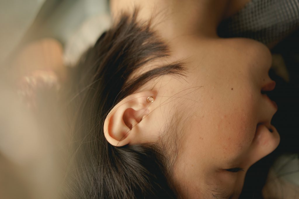 Woman lying on her side with a focus on the ear